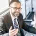 Professional health insurance brokers for small business discussing coverage options with a client in a modern office setting.
