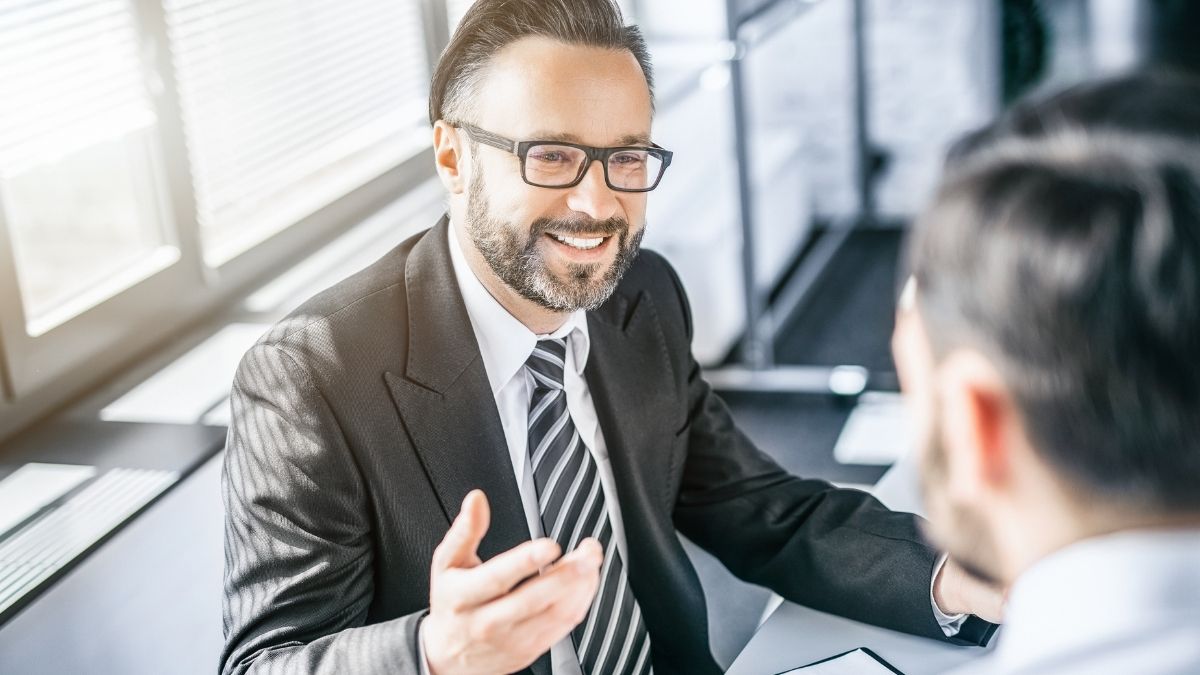 Professional health insurance brokers for small business discussing coverage options with a client in a modern office setting.