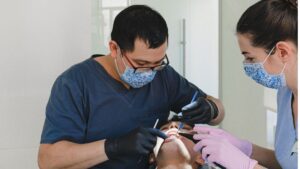 Dentists performing a dental procedure on a patient, representing services covered by Delta Dental of Colorado.