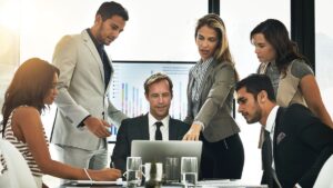 Team of professionals discussing Colorado small business health insurance options during a meeting with charts and laptop in a modern office.
