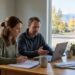 A Colorado family at a kitchen table marking a calendar and reviewing plan options for when does open enrollment begin in Colorado
